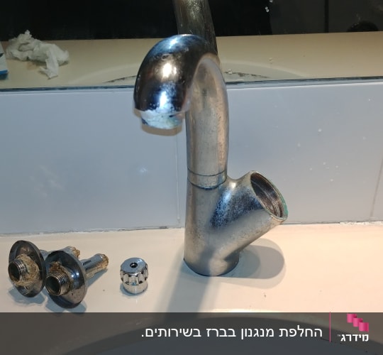 ברז מתכת מפורק עם חלקים על השיש